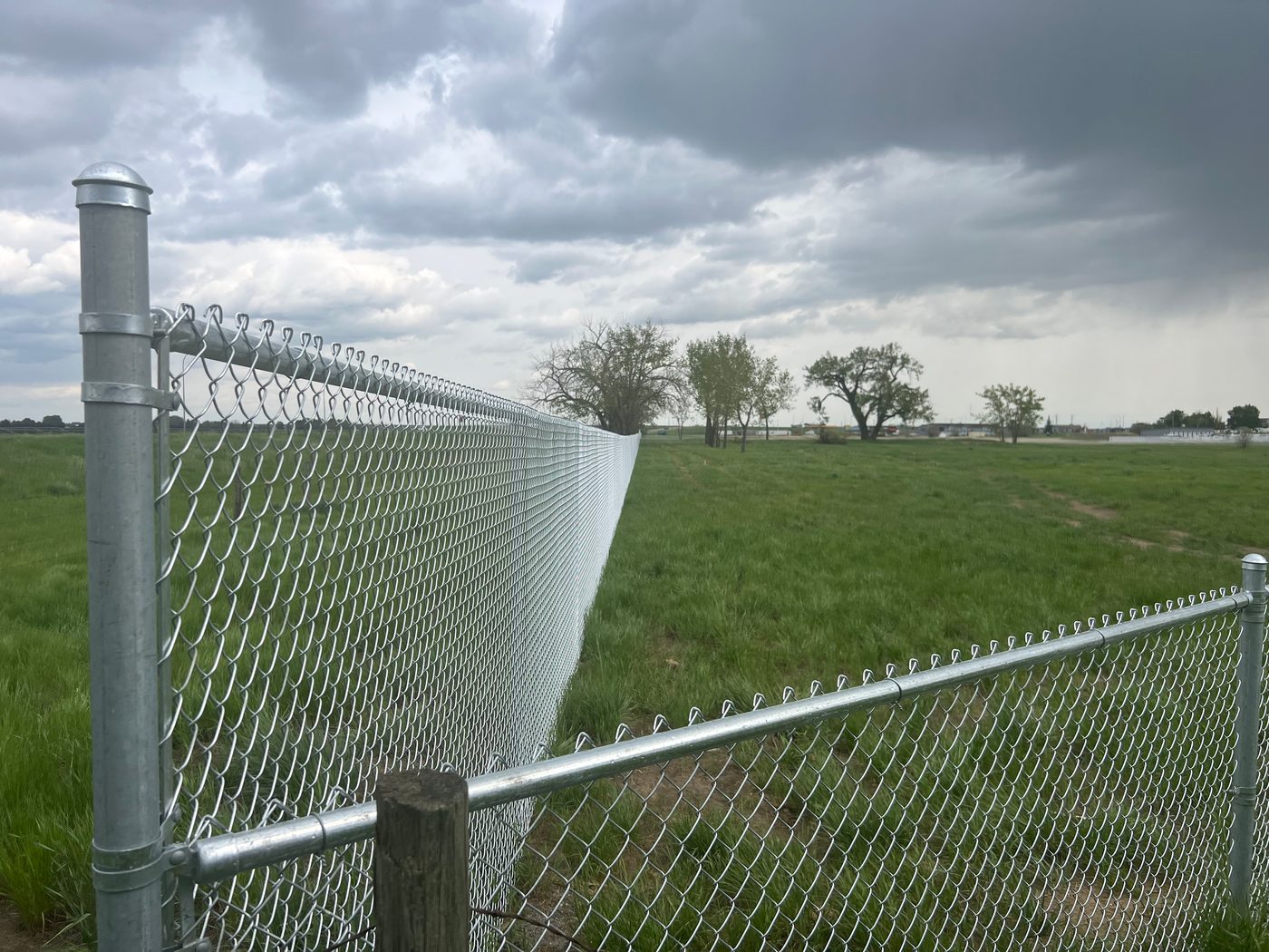 Galvanized chain-link fence along an open field